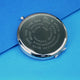 Silver compact mirror with personalised spiral message in typewriter font engraved on the front, shown in close up shot on blue background.
