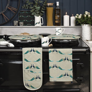 Peacock print oven glove and tea towel on black Aga
