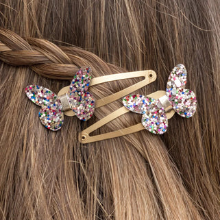 set of two sequin butterfly hair clips shown in close up shot on models hair.