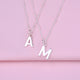 Close up detail of modern initial letter charm necklaces shown close up