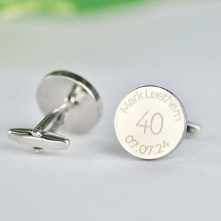 Personalised milestone 40th year birthday cufflinks with name and date engraved around the top and bottom, shown in close up shot with one cufflink turned around.