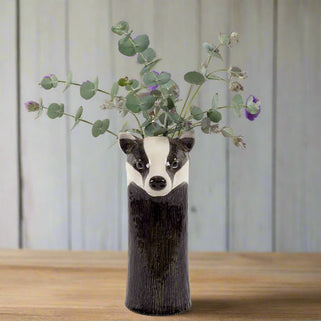 Vase shaped like a badger with eucalyptus leaves on a white background