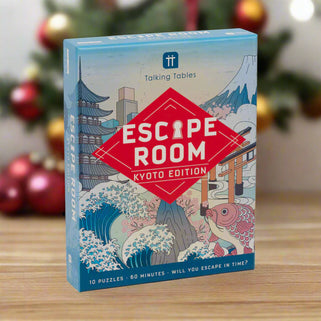 A boxed game titled 'Escape Room Kyoto Edition' featuring an illustration of a traditional Japanese cityscape with a fish market, a red torii gate, and a mountain in the background. The game is indicated for ages 14 and up, with 10 puzzles, and a playtime of 60 minutes.