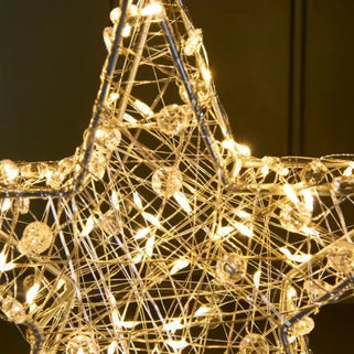 Decorative star-shaped light fixture with warm glow on a dark background
