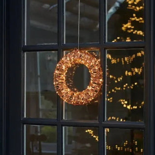 Decorative wreath with lights on a black door