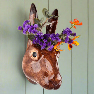 Ceramic hare head vase with floral arrangement on a white background