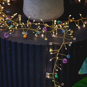 Decorative string lights with colorful beads on a black surface