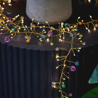 Decorative string lights with colorful beads on a black surface