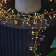 Decorative string lights with colorful beads on a black surface