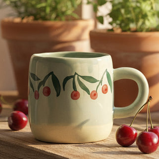 Baby Blue stoneware mug with hand painted red and green cherries around the top. 