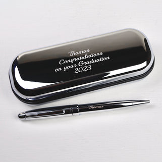 Silver chrome pen with matching case with "Thomas Congratulations on your Graduation 2023" engraved in script font shown close up shot