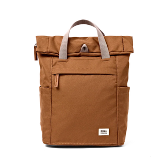A brown canvas roll-top backpack with light gray handles and a small white rectangular brand patch on the front, photographed against a solid white background.