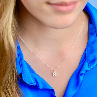 Sparkle Tiny Initial R Necklace shown on model close up