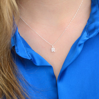 Sparkle Tiny Initial R Necklace shown on model close up