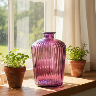 Purple glass vase with ribbed design on a white background