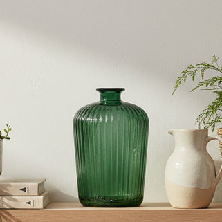 Green ribbed glass vase on a white background