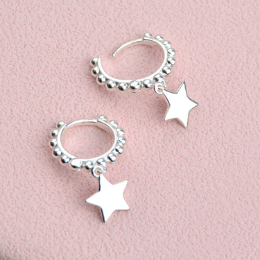 Sterling Silver beaded hoop star charm huggies shown close up with hinged opening.