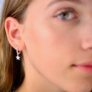 Sterling Silver beaded hoop star charm huggies shown close up on model.