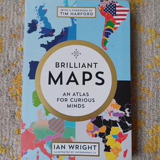 Book titled 'Brilliant Maps: An Atlas for Curious Minds' by Ian Wright on a textured surface.