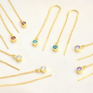 Gold birthstone threaders with Garnet/Jan, Blue Topaz/December, Amethyst/Feb and Clear/April birthstones shown close up 