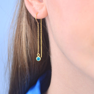 Gold birthstone threader with Blue Topaz/December birthstone shown close up on model