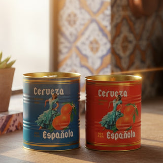 Two cans of Cerveza Española with colorful labels featuring a dancer and orange.