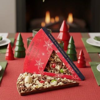 Chocolate pizza slice with toppings on a branded box against a white background