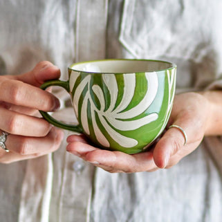 green Heiki mug shown in close up shot of someone holding 