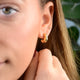 Gold Molten Misshapen Huggie Hoop Earrings shown in close up shot on model