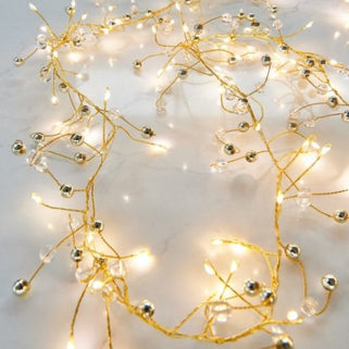 Decorative string lights with gold accents on a light background