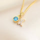 Gold Sparkle Kiss necklace with blue topaz birthstone shown close up .