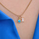 Gold Sparkle Kiss necklace with blue topaz birthstone shown close up