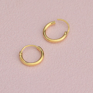 Simple Gold Sleeper Huggie Hoop Earrings shown close up