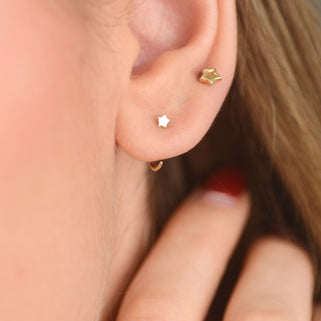 Gold Tiny Star Sleeper Pull Through Hoop Earrings shown in close up shot on model