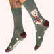 Green socks with a dog design worn by a person on a white background