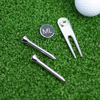 Golf Ball marker and tee set shown close up with engraving on ball marker
