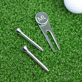 Golf Ball marker and tee set shown close up with engraving on ball marker