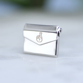 Good luck envelope pin with fingers crossed icon on front.