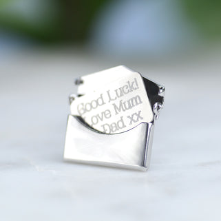 Good luck pin badge with "Good Luck! Love Mum & Dad xx" engraved on letter shown in close up shot.