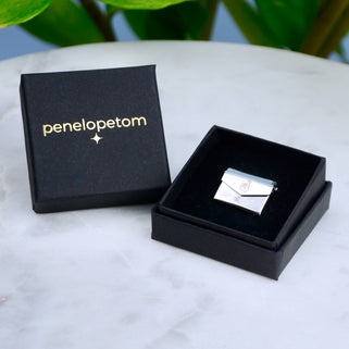 Good luck pin badge shown in Penelopetom box