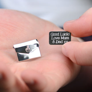 Good luck pin badge with "Good Luck! Love Mum & Dad xx" engraved on letter and fingers crossed icon engraved on the envelope