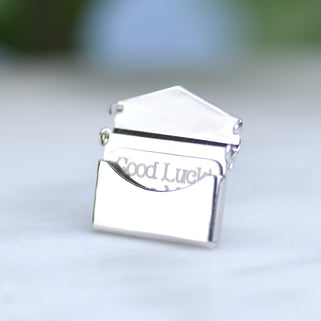 Good luck pin badge with letter shown inside of envelope.