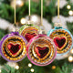 Colorful heart-shaped Christmas ornaments hanging against a white background