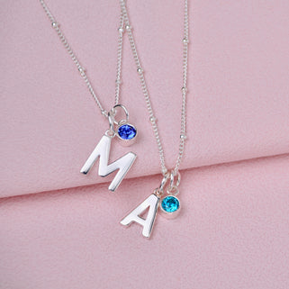 Modern initial letter M and A with sapphire and blue topaz birthstone shown close up on satellite chain