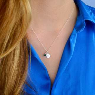 Silver landmark birthstone necklace shown close up on model