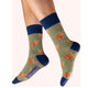 Green socks with highland cow pattern and blue cuffs worn by a person on a white background