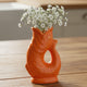 Orange ceramic fish-shaped vase on a white background