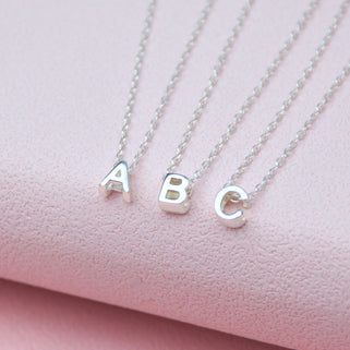 Silver mini slider initial charms shown close up