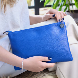 Personalised Large Leather Clutch or Crossbody Bag shown in cobalt blue with engraved circle dis charm