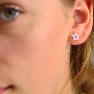 Sterling Silver CZ Open Star Stud Earrings shown close up on a model.